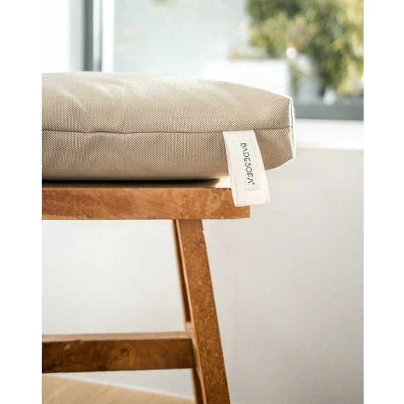 Detailansicht des Badesofa Sitzkissens in Beige mit sichtbarem Label auf Holzstuhl